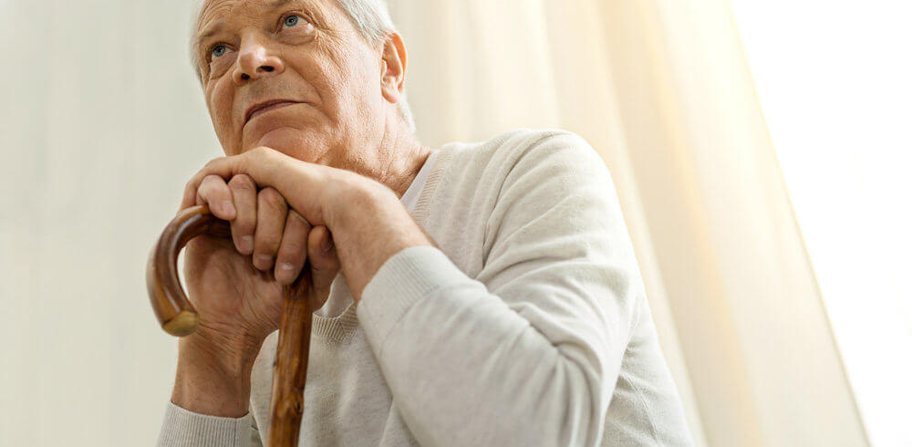 Aged man leaning on a cane Aged man leaning on a cane