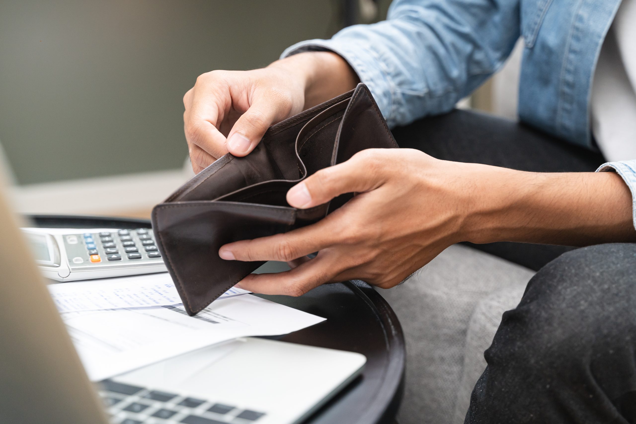 Young man opening empty wallet stress to find money after a car accident.